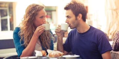 Man and woman drink coffee together and look into each other's eyes as an example that he just wants to be friends