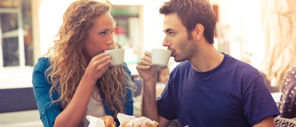Man and woman drink coffee together and look into each other's eyes as an example that he just wants to be friends