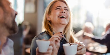 Man and woman drinking coffee and laughing as example for second date ideas