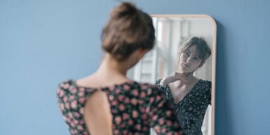 Woman looks thoughtfully in the mirror and is unlucky in love
