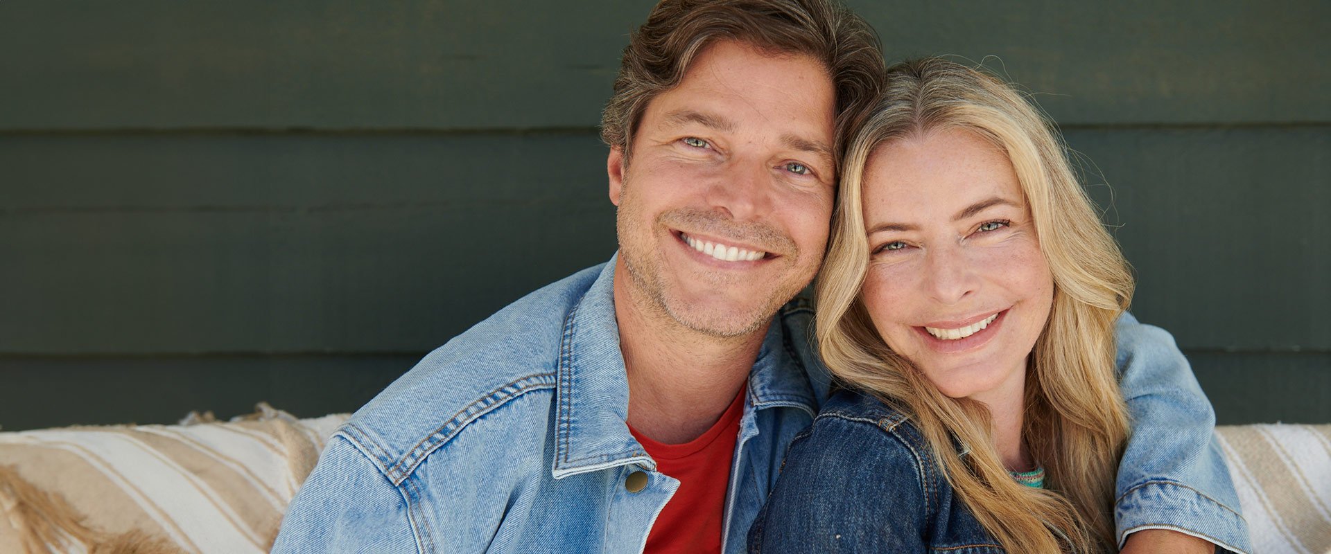 Man and woman over 50 smiling to camera as a couple