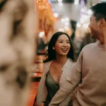 A woman and a man are walking together and laughing, symbolizing asian dating