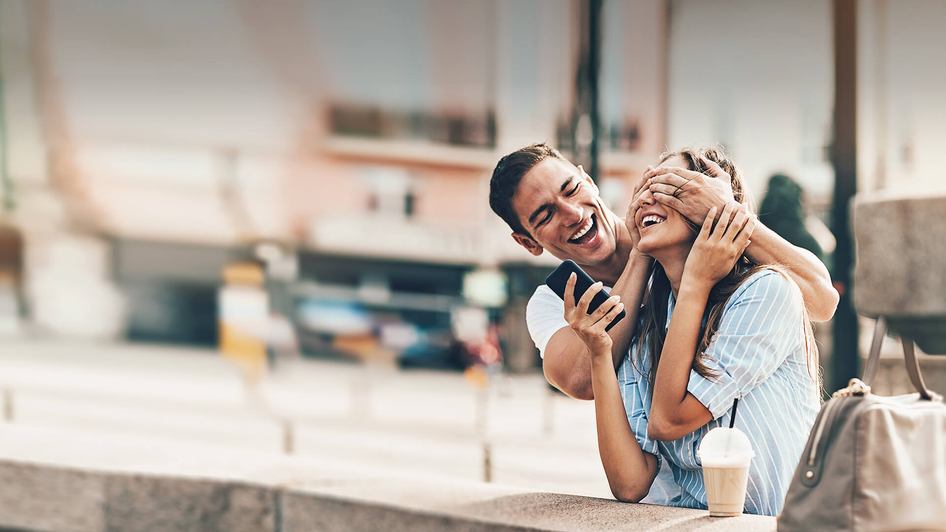 International dating site symbolized by a man who covers the eyes of his date and makes fun with her