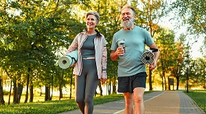 A couple carrying yoga mats are on their way to an outdoor workout. (Generated with AI)