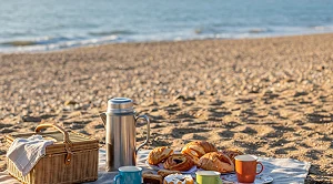 A picnic blanket with snacks at the beach.