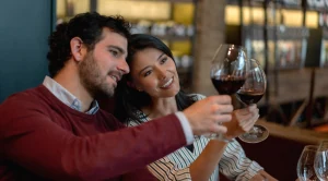 A couple looking at their glasses at a wine tasting. (Generated with AI) (Generated with AI)