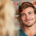 A man making eye contact with a woman.