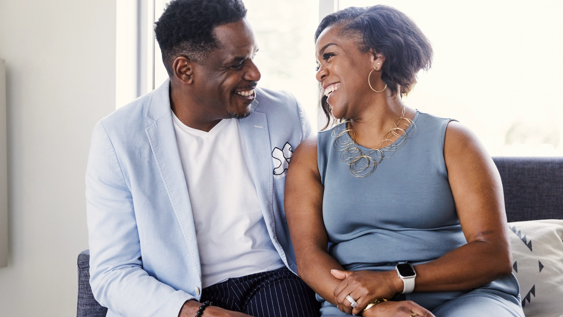 A black christina couple sitting side by side and laughing.